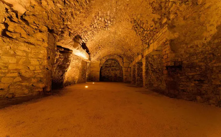 Couloir des souterrains de l'amphithéâtre d'Arles baigné d'une lumière couleur flamme